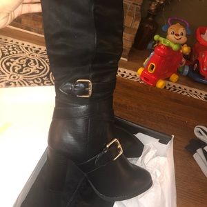 Tall black leather boots with heel.